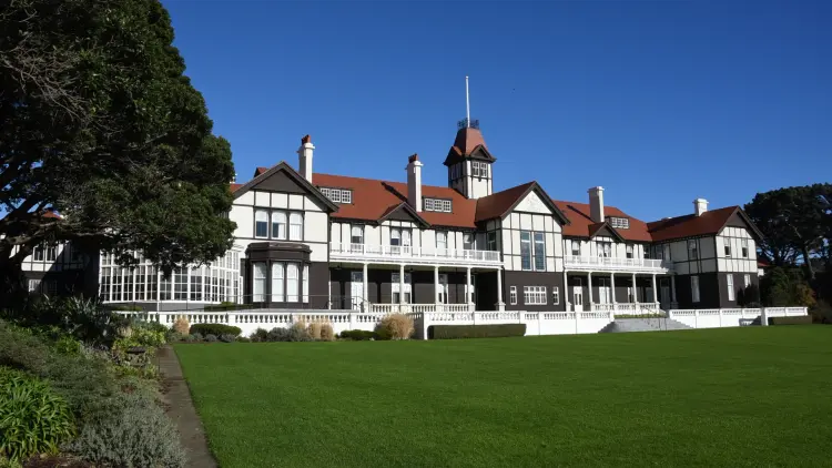 Large white house with a green lawn and blue skies