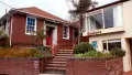 Exterior shot of brick building with stairs, reading Quakers