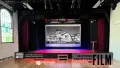 A stage with a black and white picture projected on the screen