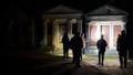 Tour group shining a torch on a crypt in Karori Cemetery at night