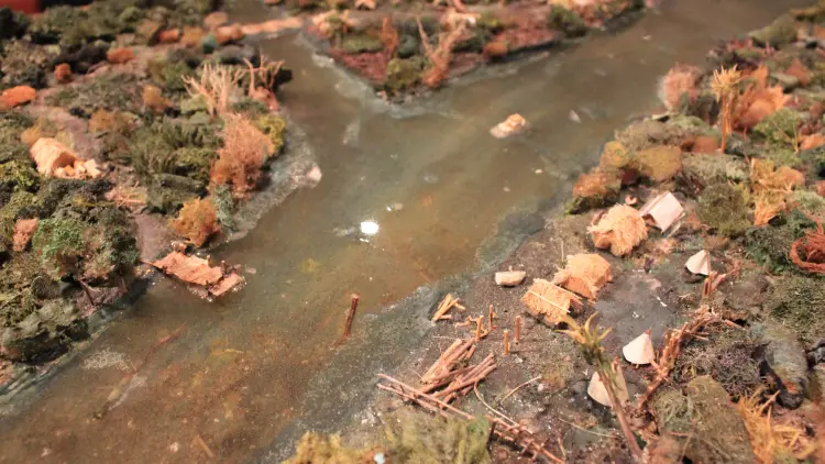 Close up shot of a diorama showing a Māori pā site along a river.