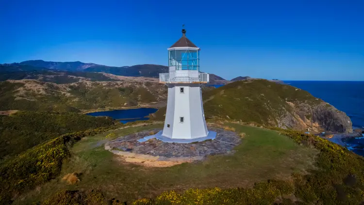 White lighthouse on grassy cliff