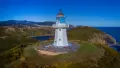 White lighthouse on grassy cliff