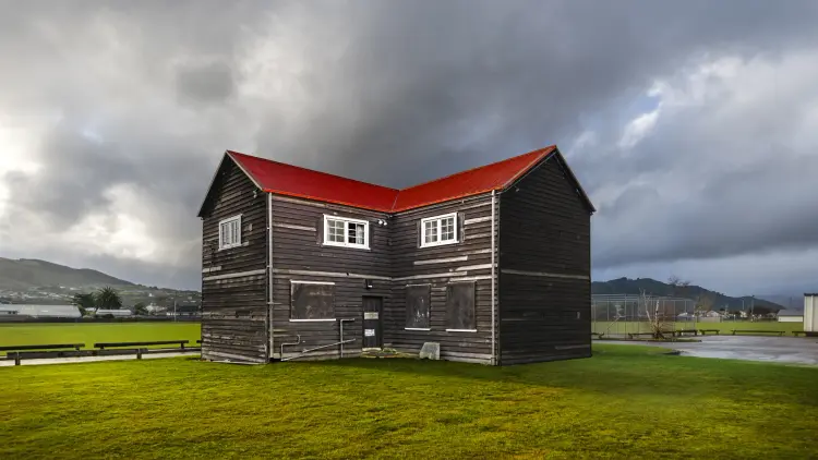 Farmhouse with red roof in a field of grass
