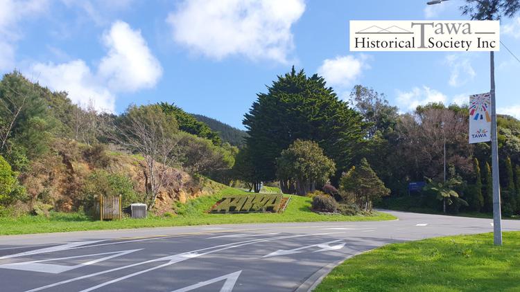 Photo showing the road leading into Tawa and the Tawa planted garden sign. The Image has the Tawa Historical Society logo.