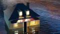 Cottage with lights on submerged in flood water